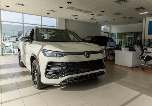 White Volkswagen SUV parked inside the showroom at Flow Volkswagen of Winston-Salem